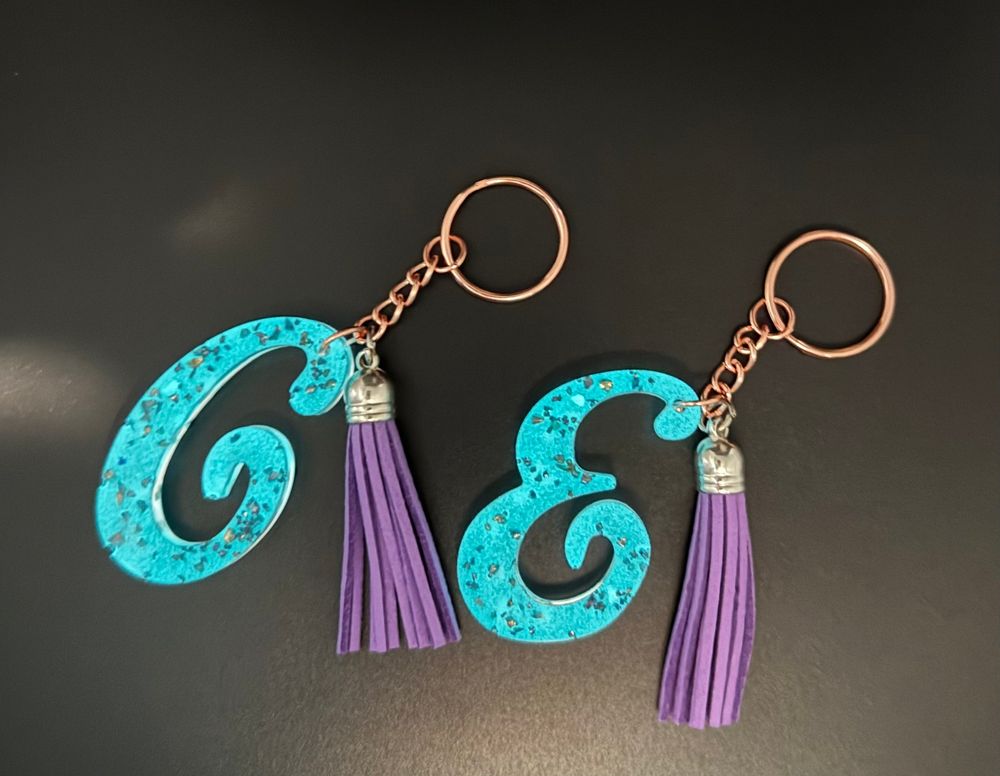 Glow in the dark turquoise keychain with a purple tassel